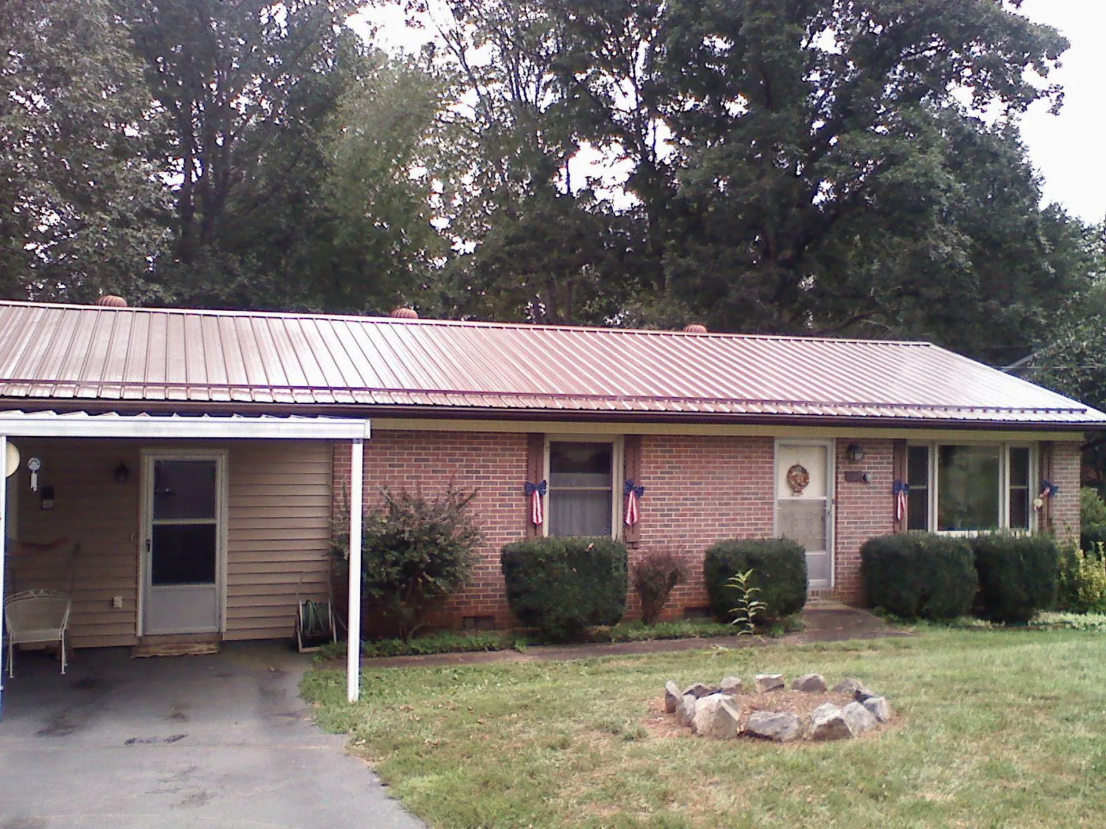 Bronze metal roof and carport on a brick ranch home — Roof Repair work by our crew in Tensed